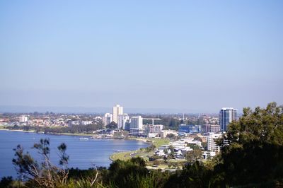 High angle view of buildings and sea against clear sky