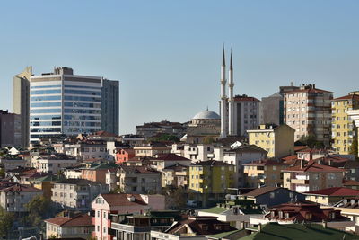 Buildings in city against clear sky