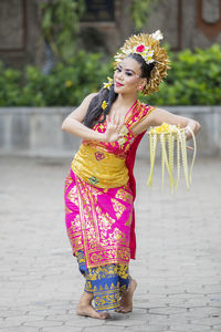 Portrait of woman in traditional clothing dancing on footpath