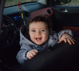 Portrait of cute baby girl in car