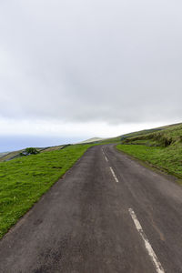 Road amidst land against sky