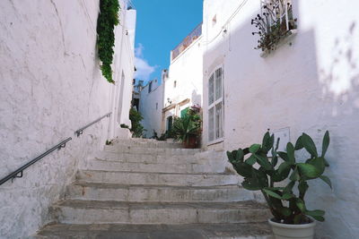Low angle view of steps amidst buildings against sky