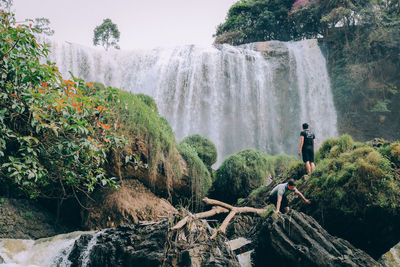 Scenic view of waterfall against trees