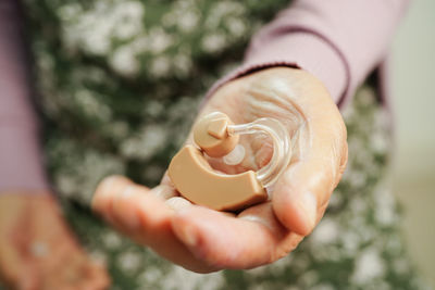 Cropped hand of woman holding bottle