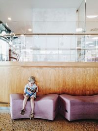 Full length of boy sitting on seat