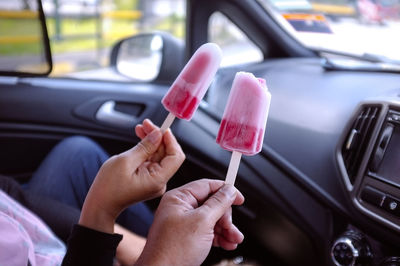 Close-up of hand holding ice cream cone in car