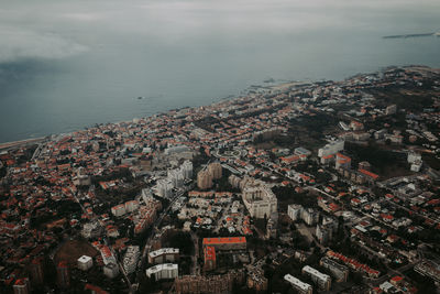 High angle view of townscape by sea against sky