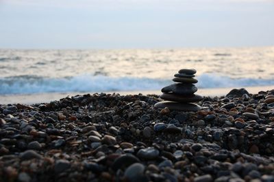 Close-up of pebbles on beach against sky