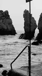 Rock formation on beach against sky