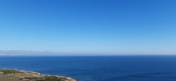 Scenic view of sea against clear blue sky