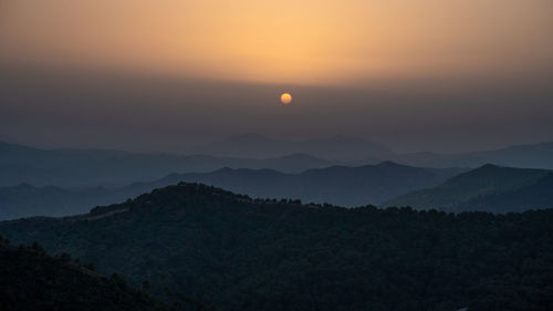 Scenic view of silhouette mountains against sky during sunset