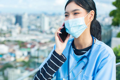 Portrait of beautiful young woman standing in city