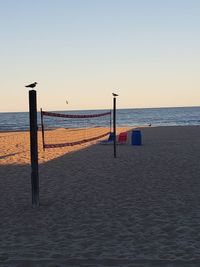 Scenic view of beach against clear sky during sunset