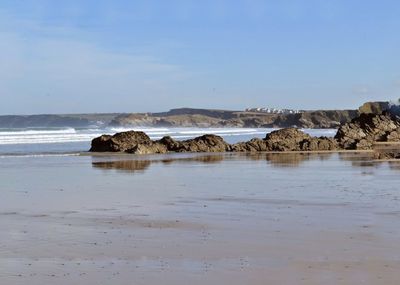 Rocks on beach against sky