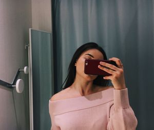 Portrait of woman photographing with mobile phone