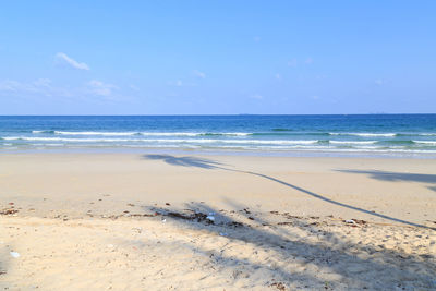 Scenic view of beach against blue sky