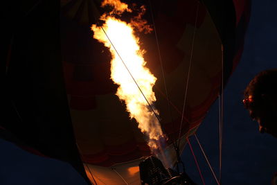 Low angle view of man by hot air balloon at night