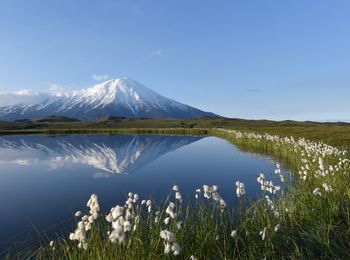 Scenic view of lake by mountains against sky