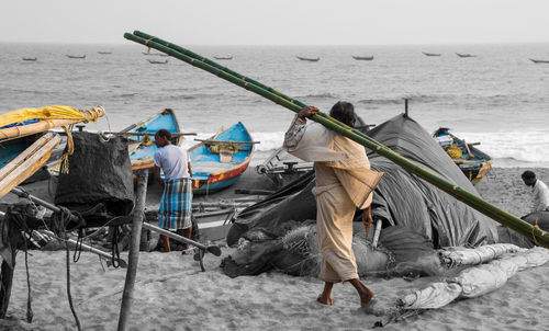 Rear view of people working in sea