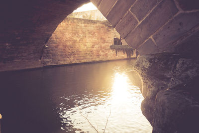 Bridge over river against buildings