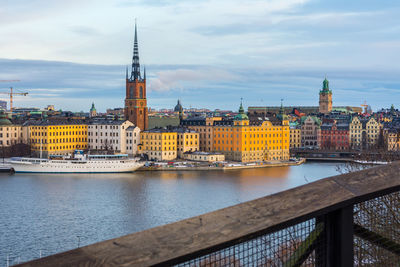 View of buildings at waterfront against cloudy sky