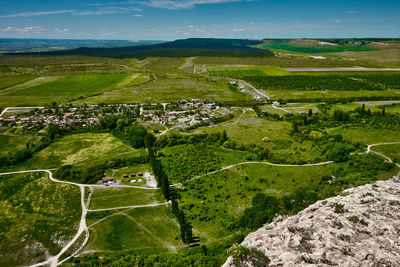 High angle view of road amidst field against sky