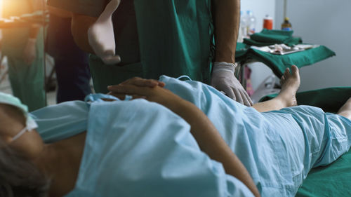 Low section of doctor examining patient in hospital