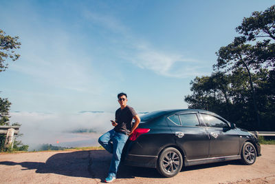 Full length of man standing by car