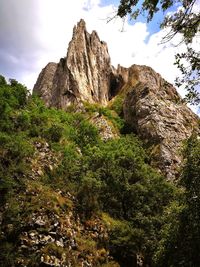 Low angle view of rocks on mountain against sky