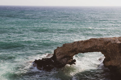 Rock formation in sea against sky