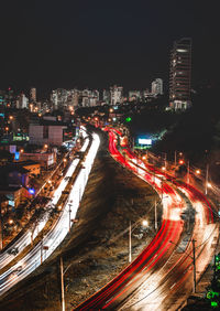 High angle view of illuminated street amidst buildings at night