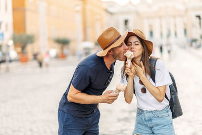 Happy couple eating ice cream in rome, italy. beautiful bright ice cream  in the hands