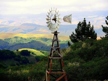 Traditional windmill on field against sky