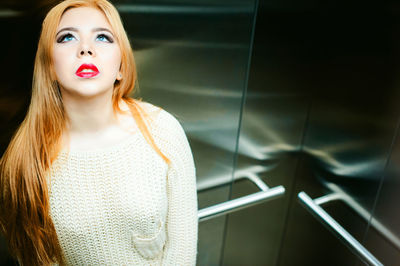 Thoughtful young woman standing in elevator