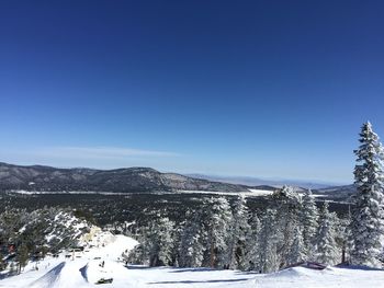 Scenic view of snow covered mountain against clear blue sky