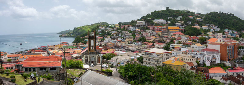 High angle view of townscape by sea against sky