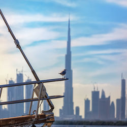 Close-up of airplane flying in city against cloudy sky