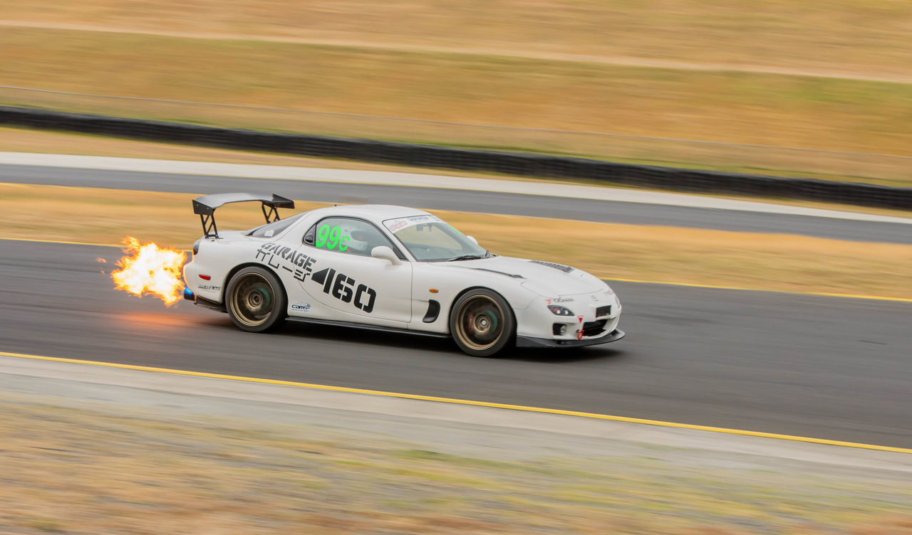 mode of transportation, motion, transportation, blurred motion, speed, car, motor vehicle, road, land vehicle, on the move, no people, competition, sports race, travel, moving, outdoors, day, sign, number