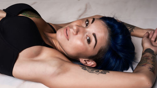 High angle portrait of young woman in bikini lying on bed