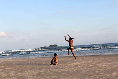 People enjoying on beach against sky