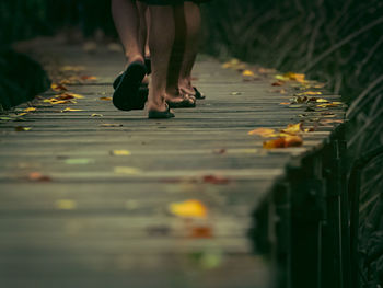 Low section of woman standing on footpath