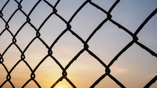 Close-up of chainlink fence against sky