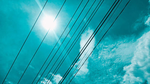 Low angle view of cables against blue sky