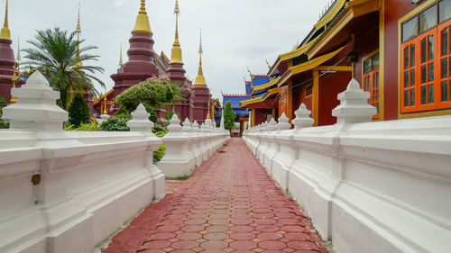 Footpath amidst buildings against sky