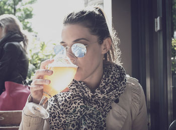 Young woman drinking water from coffee cup