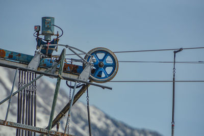 Low angle view of cable transportation against clear blue sky