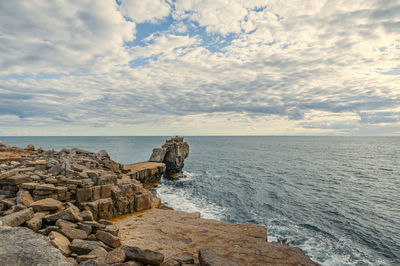 Scenic view of rocks in sea against sky.  pulpit rock on isle of portland in dorset coastline. uk