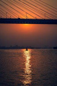 Silhouette of suspension bridge at sunset