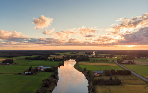 The late summer sun sets over the river. the sky is very dramatic in this aerial view.