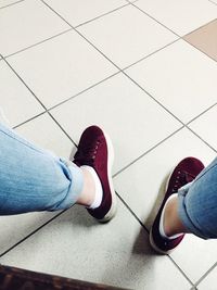 Low section of man standing on tiled floor